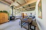Experience cozy living in this spacious room featuring a modern wood-burning stove and large windows that offer abundant natural light and scenic views.