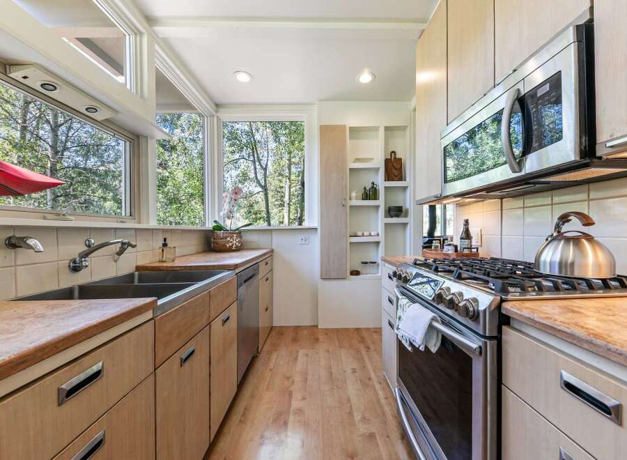 This charming kitchen boasts a spacious double sink and ample wooden cabinetry, perfect for storage and meal preparation.
