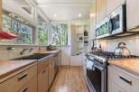 This charming kitchen boasts a spacious double sink and ample wooden cabinetry, perfect for storage and meal preparation.