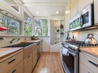 This charming kitchen boasts a spacious double sink and ample wooden cabinetry, perfect for storage and meal preparation.