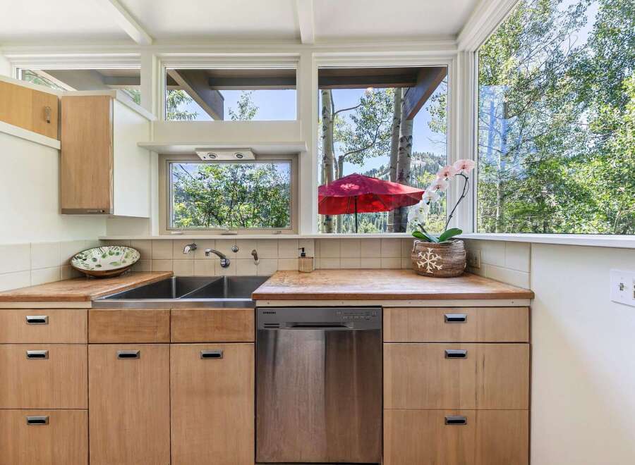 This charming kitchen boasts a spacious double sink and sleek stainless steel dishwasher, perfect for any home chef.