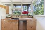 This charming kitchen boasts a spacious double sink and sleek stainless steel dishwasher, perfect for any home chef.