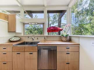 This charming kitchen boasts a spacious double sink and sleek stainless steel dishwasher, perfect for any home chef.