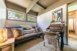 Cozy up in this charming room featuring a comfortable brown sofa adorned with plush pillows and throws.