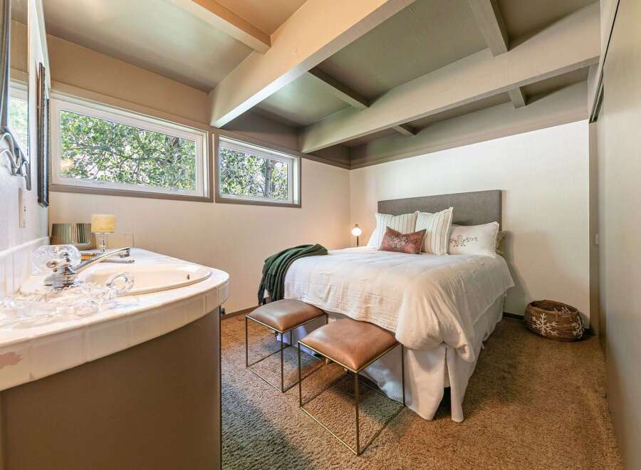 Discover this charming bedroom featuring a cozy bed with plush pillows and a decorative throw.