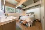 Discover this charming bedroom featuring a cozy bed with plush pillows and a decorative throw.