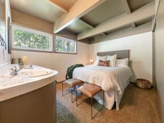 Discover this charming bedroom featuring a cozy bed with plush pillows and a decorative throw.