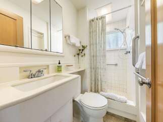 This bright and clean bathroom features a spacious vanity with a modern faucet and a large mirrored medicine cabinet.
