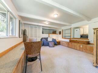 Discover this charming living space featuring a cozy seating area with a plush sofa and a woven chair, perfect for relaxation.