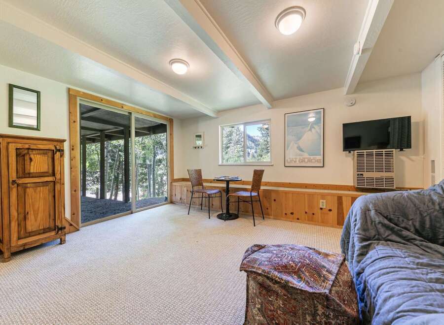This cozy living space features a rustic wooden cabinet and a comfortable sofa, perfect for relaxing after a day of outdoor adventures.