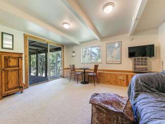 This cozy living space features a rustic wooden cabinet and a comfortable sofa, perfect for relaxing after a day of outdoor adventures.
