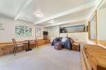 Discover this charming living space featuring a cozy blue sofa and a unique lofted sleeping area.