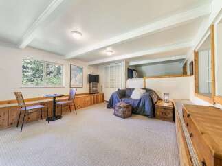 Discover this charming living space featuring a cozy blue sofa and a unique lofted sleeping area.