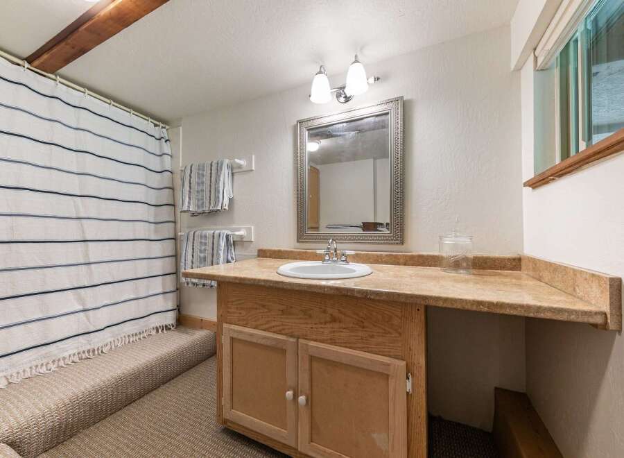 This charming bathroom features a convenient vanity with ample counter space and storage, perfect for everyday use.
