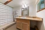 This charming bathroom features a convenient vanity with ample counter space and storage, perfect for everyday use.