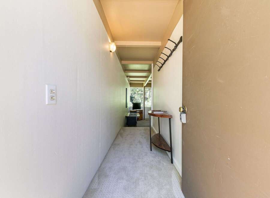 Step into this charming hallway, featuring a neutral carpet and a convenient wall-mounted coat rack.