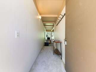 Step into this charming hallway, featuring a neutral carpet and a convenient wall-mounted coat rack.