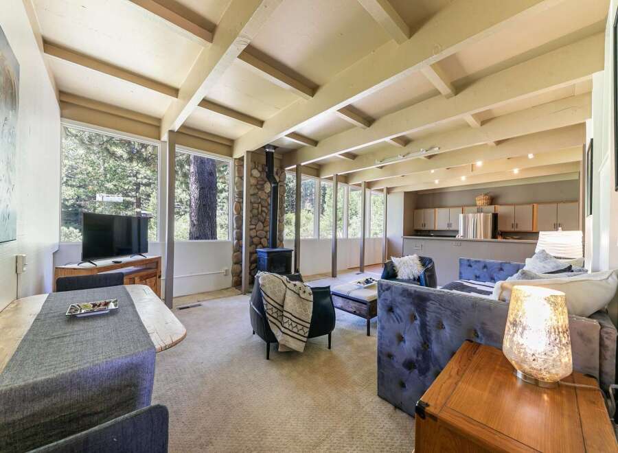 Experience cozy living in this charming home featuring a stone-clad fireplace and expansive windows that bring the outdoors in.