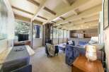 Experience cozy living in this charming home featuring a stone-clad fireplace and expansive windows that bring the outdoors in.