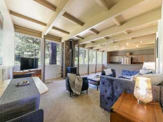 Experience cozy living in this charming home featuring a stone-clad fireplace and expansive windows that bring the outdoors in.