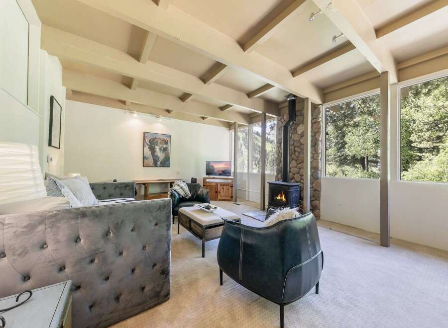 Experience cozy living in this inviting living room, featuring a striking stone-clad fireplace as the focal point.