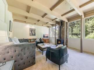 Experience cozy living in this inviting living room, featuring a striking stone-clad fireplace as the focal point.