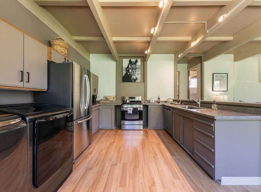 Discover this charming kitchen featuring sleek stainless steel appliances, including a modern refrigerator and a gas range.