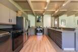 Discover this charming kitchen featuring sleek stainless steel appliances, including a modern refrigerator and a gas range.
