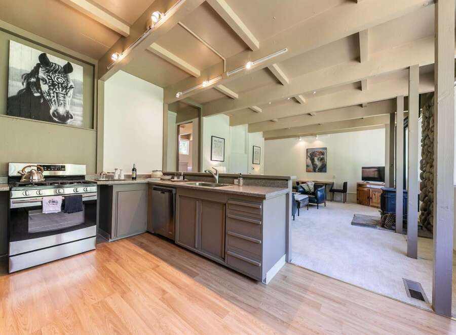 Experience a unique living space with a striking black and white horse portrait above a modern kitchen.