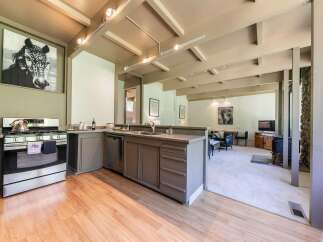 Experience a unique living space with a striking black and white horse portrait above a modern kitchen.