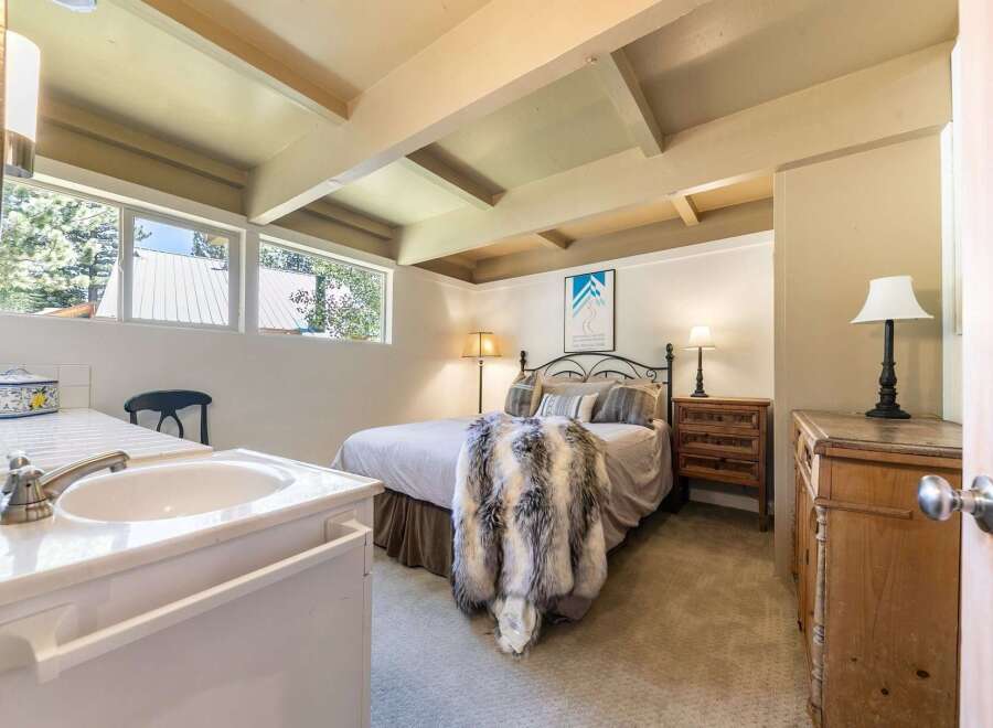 This charming bedroom features a cozy queen-size bed adorned with a luxurious faux fur throw, perfect for relaxing evenings.
