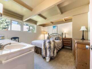 This charming bedroom features a cozy queen-size bed adorned with a luxurious faux fur throw, perfect for relaxing evenings.