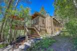 Nestled amidst lush greenery, this charming home offers a unique living experience with its elevated deck and multiple staircases leading to different levels.