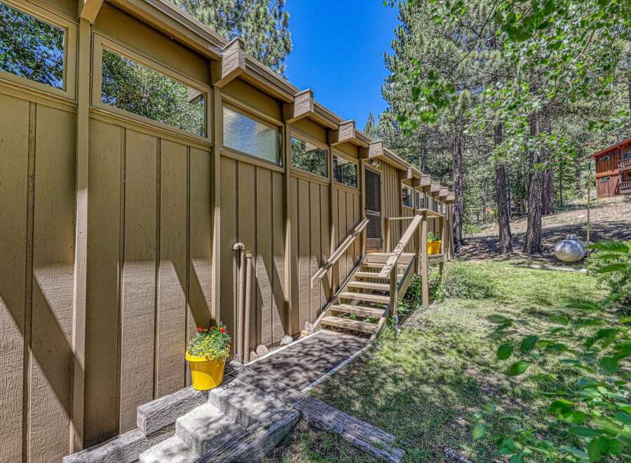 Nestled amongst tall pine trees, this charming home offers a serene mountain retreat.