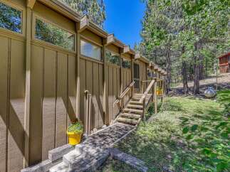 Nestled amongst tall pine trees, this charming home offers a serene mountain retreat.