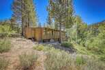 Nestled amidst towering pines and lush greenery, this charming wooden cabin offers a serene mountain retreat.