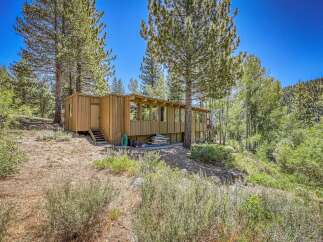 Nestled amidst towering pines and lush greenery, this charming wooden cabin offers a serene mountain retreat.