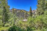 Nestled amidst lush greenery and towering trees, this property offers a serene mountain escape.