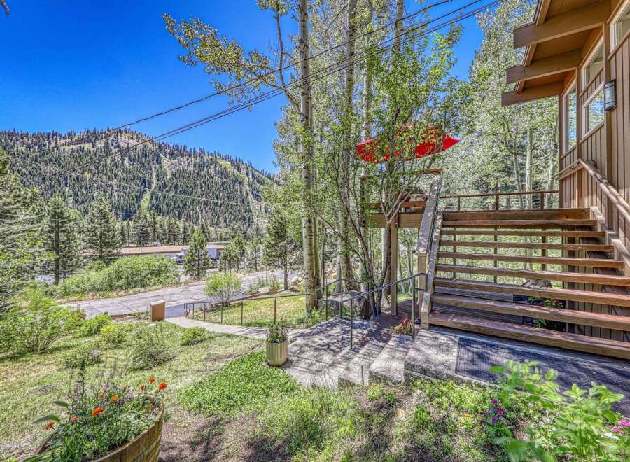 Nestled amidst towering trees and a scenic mountain backdrop, this property offers a unique blend of natural beauty and comfortable living.