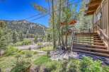 Nestled amidst towering trees and a scenic mountain backdrop, this property offers a unique blend of natural beauty and comfortable living.