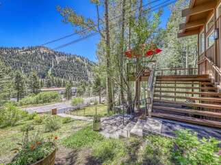 Nestled amidst towering trees and a scenic mountain backdrop, this property offers a unique blend of natural beauty and comfortable living.