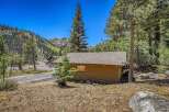 Nestled amidst towering pine trees and a picturesque mountain backdrop, this charming cabin offers a serene escape.