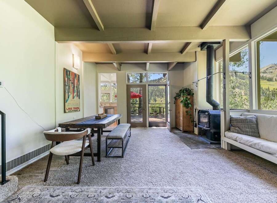 Experience breathtaking mountain views from this stunning property, featuring a cozy living area with a wood-burning stove and a spacious dining area perfect for gatherings.