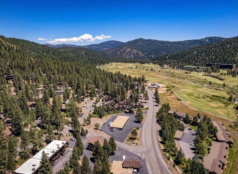 Nestled amidst a lush pine forest, this property offers a serene mountain retreat with stunning views of rolling hills and a distant valley.