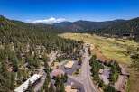 Nestled amidst a lush pine forest, this property offers a serene mountain retreat with stunning views of rolling hills and a distant valley.