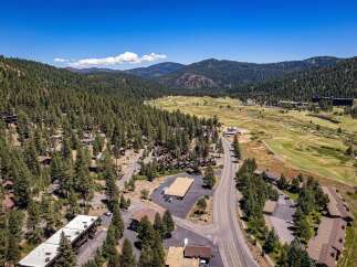 Nestled amidst a lush pine forest, this property offers a serene mountain retreat with stunning views of rolling hills and a distant valley.