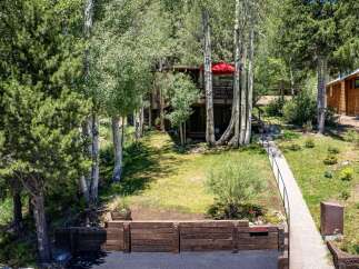 Nestled amongst mature trees, this charming home offers a serene mountain retreat.