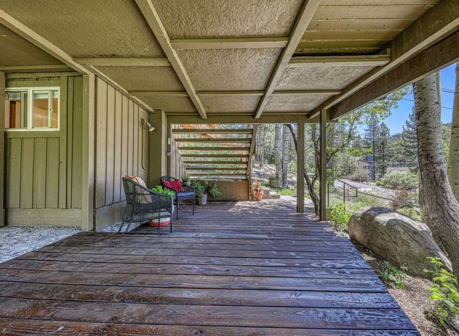 Enjoy the serene mountain setting from this charming covered deck, perfect for relaxing or entertaining.