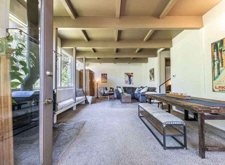 Experience rustic charm in this spacious living area featuring a cozy fireplace and exposed beam ceiling.