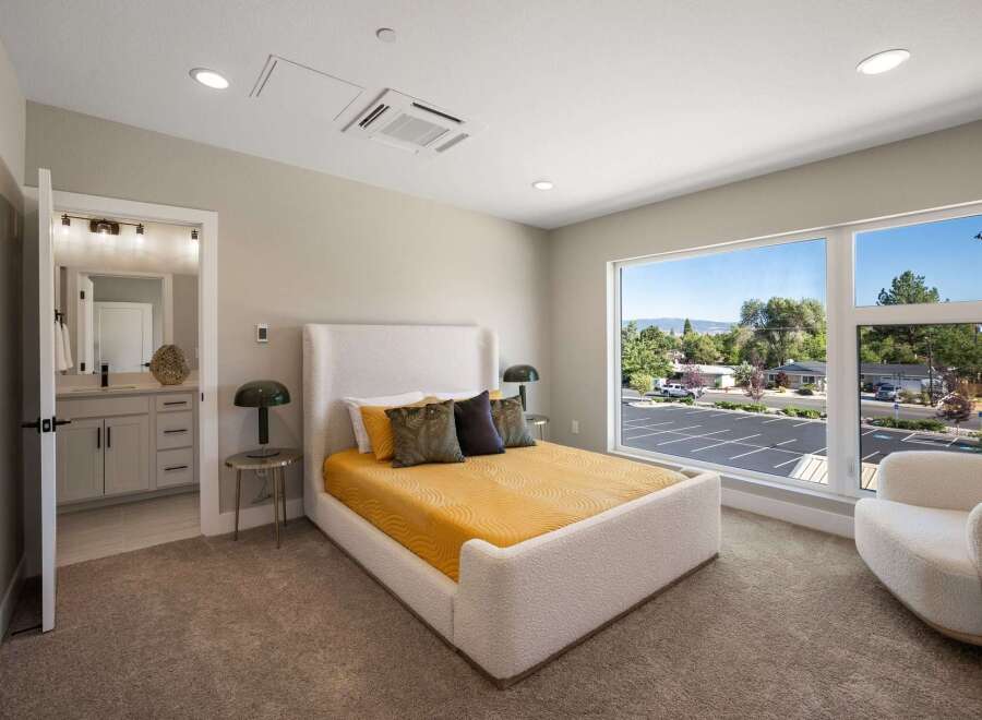 Experience modern comfort in this beautifully appointed bedroom, featuring a plush white bouclé bed and a vibrant yellow quilted comforter.